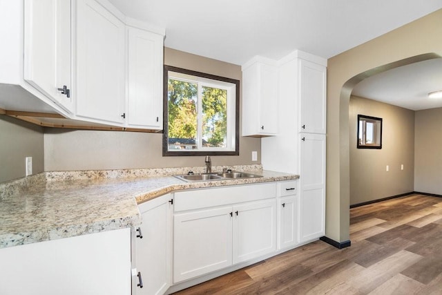 kitchen featuring white cabinets, sink, and light wood-type flooring