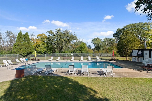 view of pool with a patio and a yard