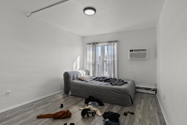 bedroom featuring a baseboard radiator, a wall mounted air conditioner, and wood-type flooring