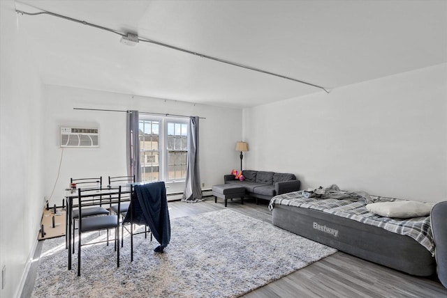 living room with hardwood / wood-style flooring, a baseboard heating unit, and an AC wall unit