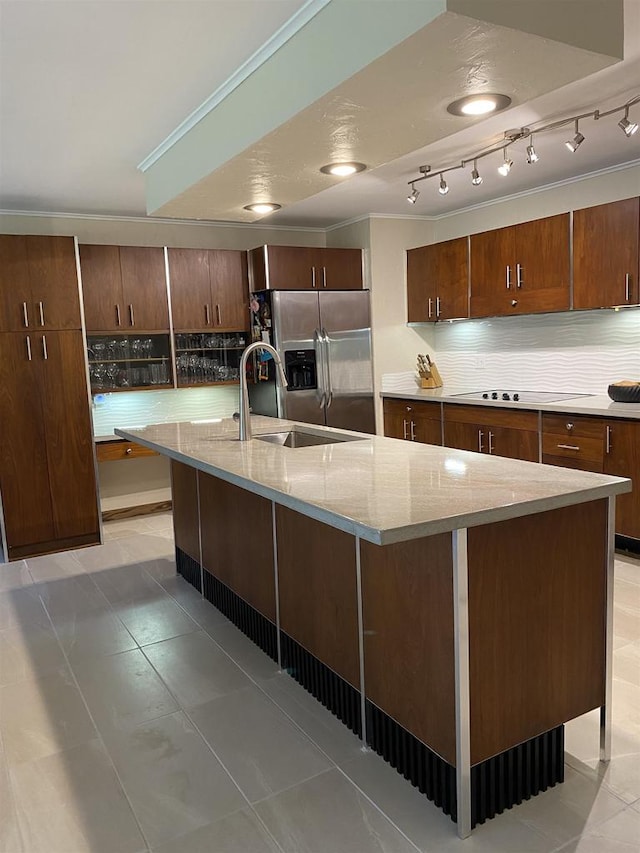 kitchen with tasteful backsplash, tile patterned floors, stainless steel fridge, and a spacious island