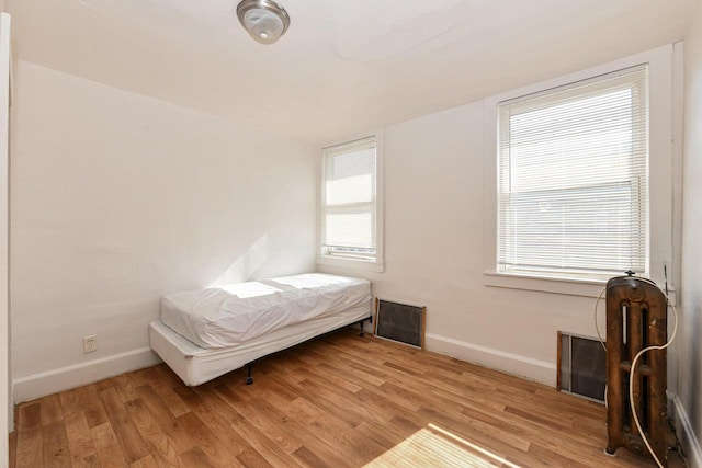 unfurnished bedroom with light hardwood / wood-style flooring and multiple windows