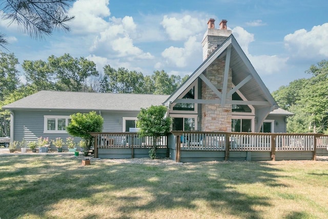 back of property featuring a wooden deck and a lawn