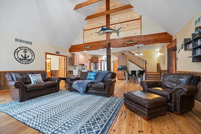 living room featuring beamed ceiling, an inviting chandelier, hardwood / wood-style floors, and high vaulted ceiling