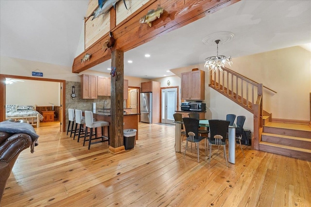 kitchen featuring a notable chandelier, light hardwood / wood-style flooring, stainless steel fridge, and tasteful backsplash