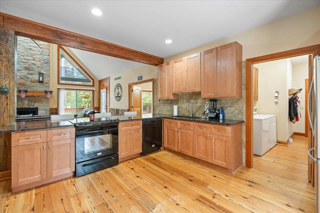 kitchen with vaulted ceiling with beams, sink, black appliances, separate washer and dryer, and light hardwood / wood-style floors