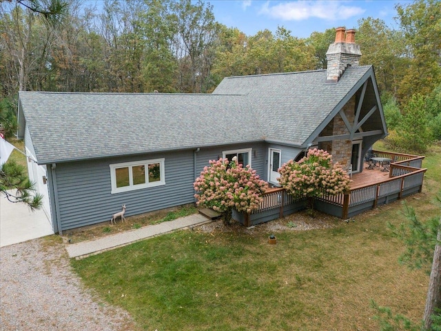 rear view of property with a deck and a yard