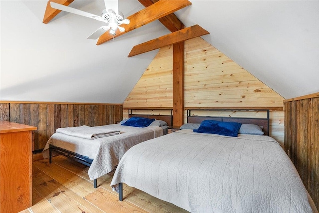 bedroom with ceiling fan, hardwood / wood-style flooring, vaulted ceiling with beams, and wood walls