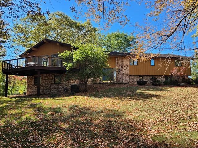 back of house featuring a wooden deck and a lawn