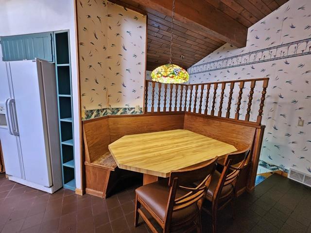 dining room featuring wood ceiling, lofted ceiling with beams, and breakfast area