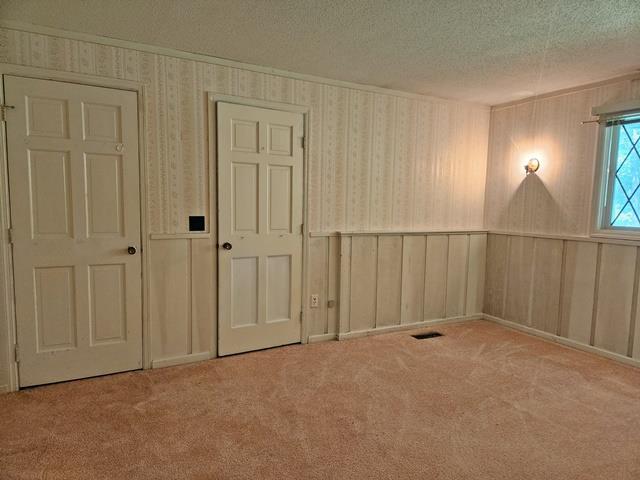 carpeted spare room with a textured ceiling