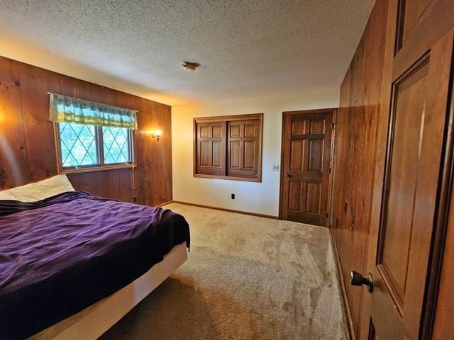 carpeted bedroom with a textured ceiling and wooden walls