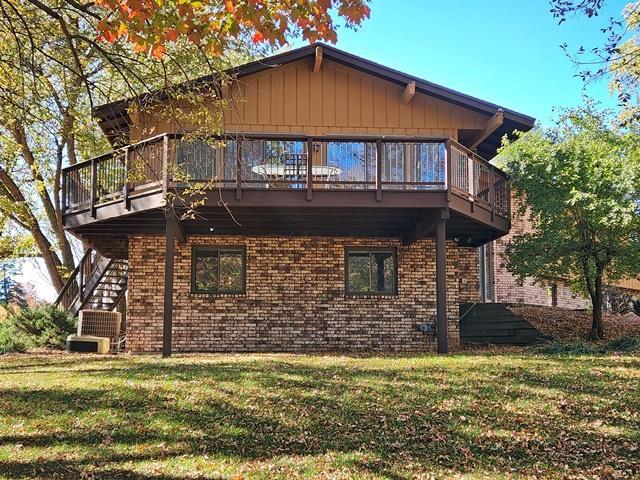 rear view of house featuring a yard and a balcony