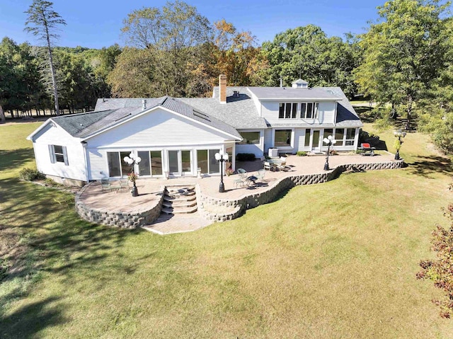 back of property with a lawn and a patio area