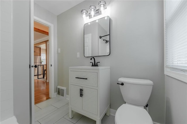 bathroom featuring tile patterned flooring, vanity, and toilet