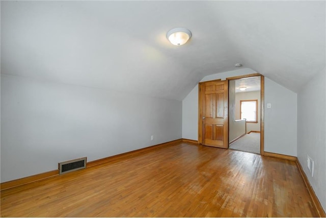 bonus room with light hardwood / wood-style floors and lofted ceiling