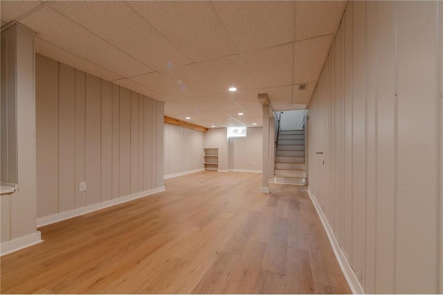 basement with wood-type flooring and a drop ceiling