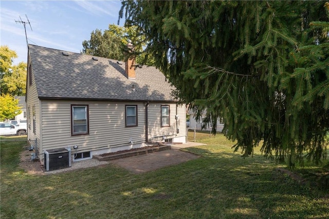 back of property with a lawn and central air condition unit