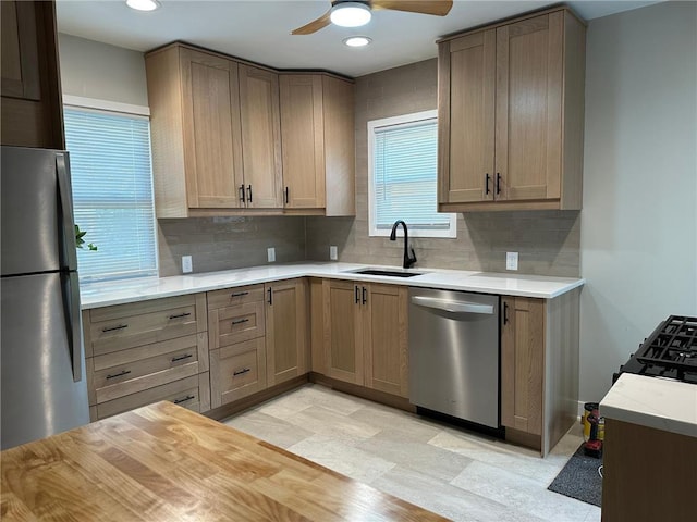 kitchen featuring backsplash, ceiling fan, sink, and appliances with stainless steel finishes