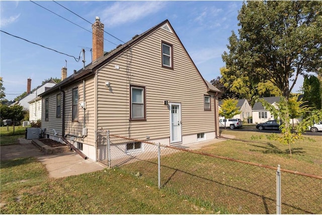 rear view of property featuring a lawn