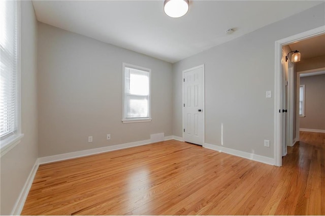 empty room with light hardwood / wood-style flooring