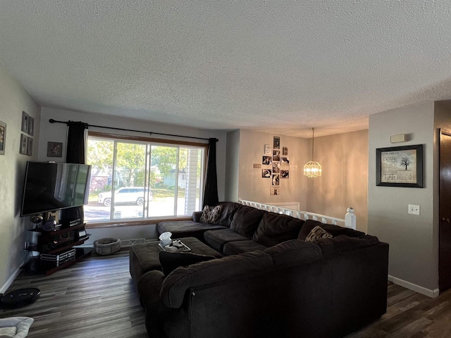 living room with an inviting chandelier, a textured ceiling, and dark hardwood / wood-style floors