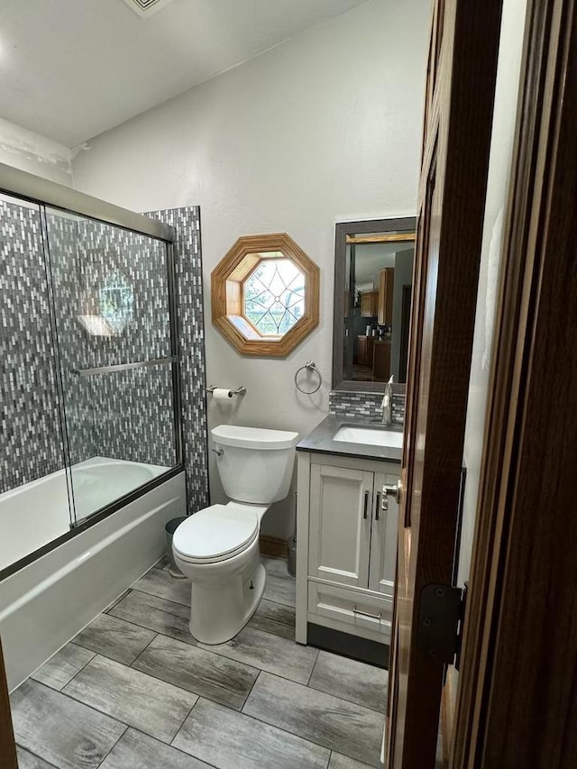 full bathroom with vanity, shower / bath combination with glass door, and toilet