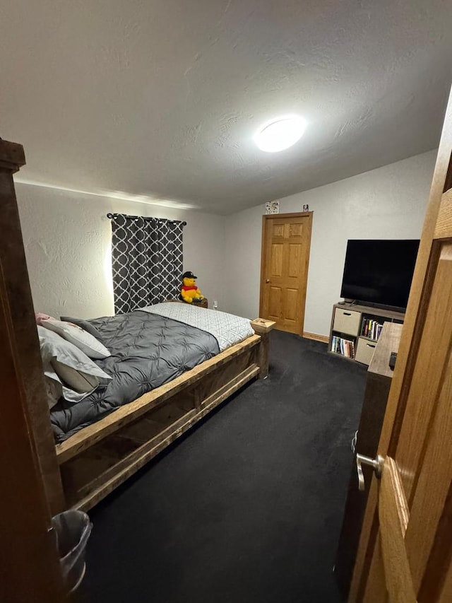 carpeted bedroom with vaulted ceiling and a textured ceiling