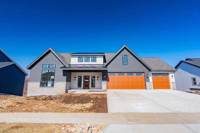 1438 Greenleaf Ct, Sun Prairie, WI 53590 - view of front of house with concrete driveway, stone siding, an attached garage, and board and batten siding