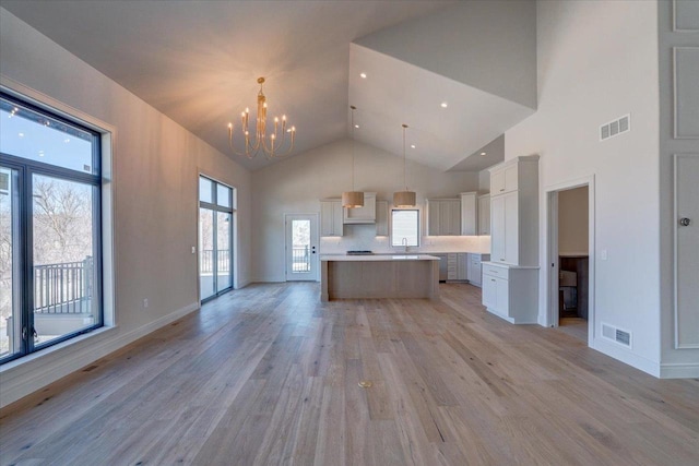 1438 Greenleaf Ct, Sun Prairie, WI 53590 - kitchen with open floor plan, visible vents, light wood-type flooring, and an inviting chandelier