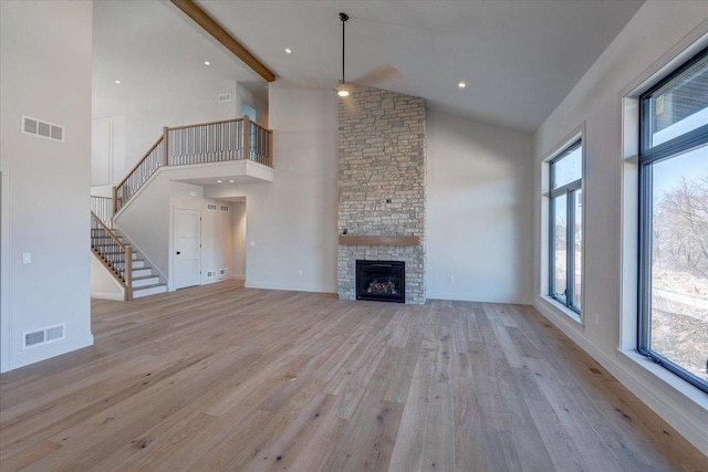 1438 Greenleaf Ct, Sun Prairie, WI 53590 - unfurnished living room featuring high vaulted ceiling, visible vents, a ceiling fan, and light wood-style flooring