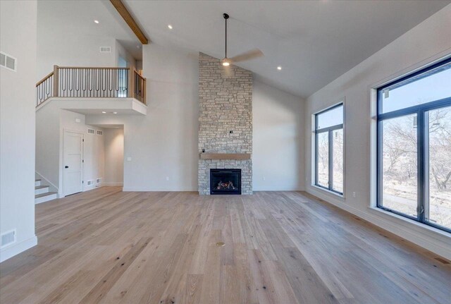 1438 Greenleaf Ct, Sun Prairie, WI 53590 - unfurnished living room featuring visible vents, light wood-type flooring, a ceiling fan, stairway, and high vaulted ceiling