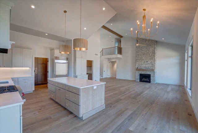 1438 Greenleaf Ct, Sun Prairie, WI 53590 - kitchen featuring a center island, built in refrigerator, light wood-type flooring, a chandelier, and high vaulted ceiling