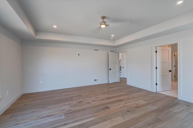 1438 Greenleaf Ct, Sun Prairie, WI 53590 - unfurnished bedroom with visible vents, light wood-type flooring, and a tray ceiling