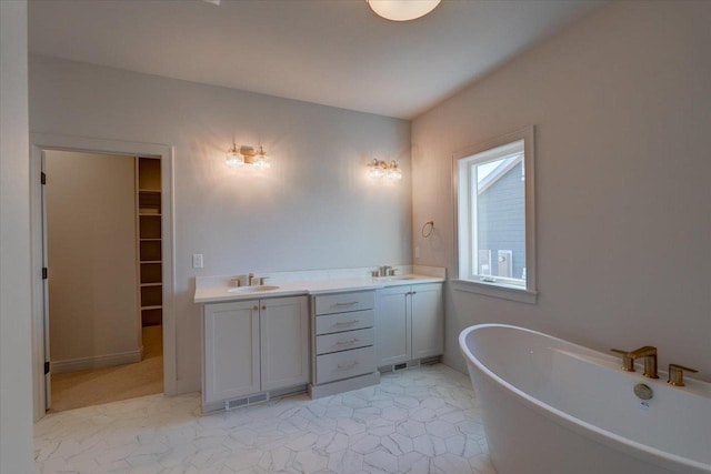 1438 Greenleaf Ct, Sun Prairie, WI 53590 - bathroom featuring a freestanding tub, double vanity, a sink, and a spacious closet