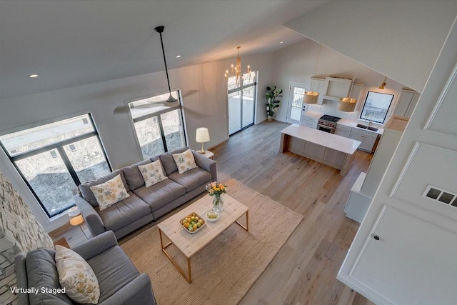 1438 Greenleaf Ct, Sun Prairie, WI 53590 - living room featuring light wood finished floors, a notable chandelier, vaulted ceiling, and visible vents
