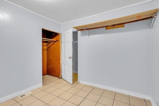 unfurnished bedroom featuring a closet and light tile patterned floors