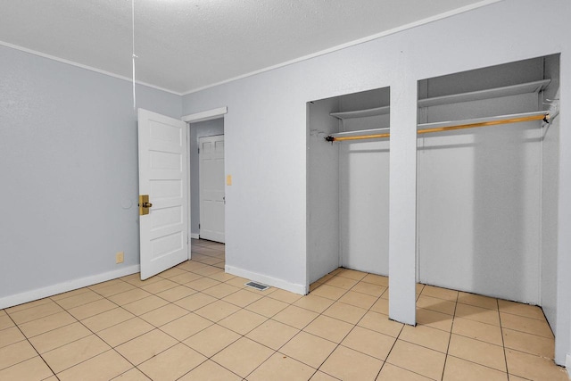 unfurnished bedroom featuring light tile patterned flooring and a textured ceiling