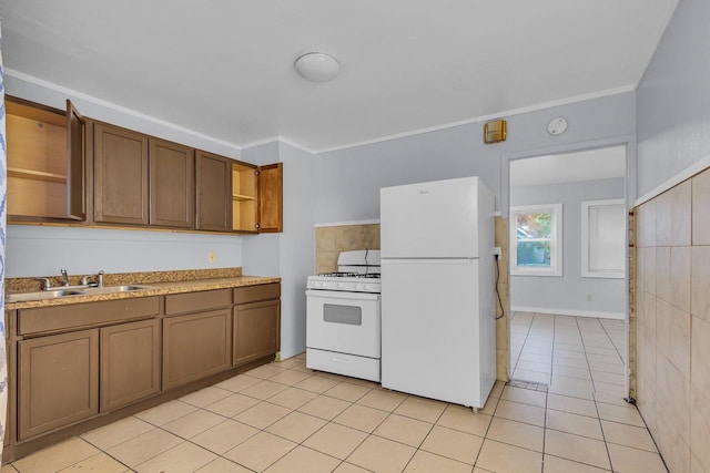 kitchen with light tile patterned floors, crown molding, sink, and white appliances