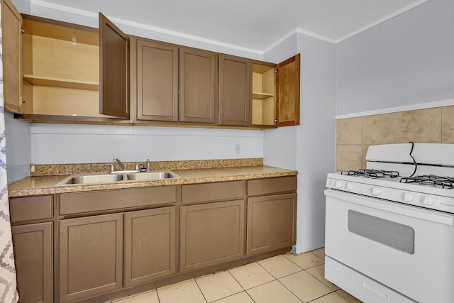 kitchen featuring gas range gas stove, sink, and light tile patterned floors