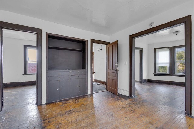 unfurnished bedroom with dark hardwood / wood-style flooring and two closets