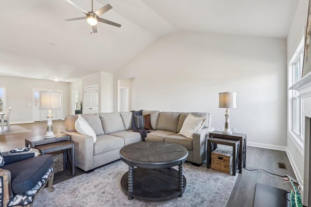 living room with lofted ceiling, ceiling fan, wood finished floors, visible vents, and baseboards