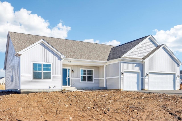 view of front of home with a shingled roof and an attached garage