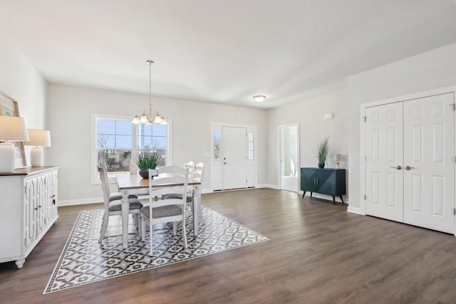 dining room featuring a chandelier, dark wood-style flooring, and baseboards