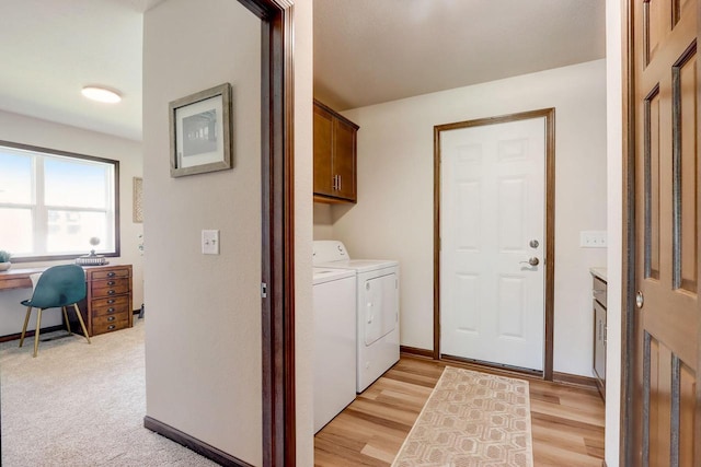 washroom with separate washer and dryer, cabinets, and light hardwood / wood-style flooring