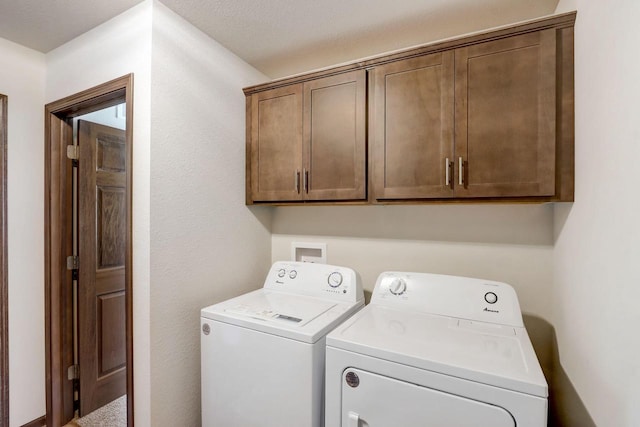 laundry area featuring cabinets, independent washer and dryer, and a textured ceiling