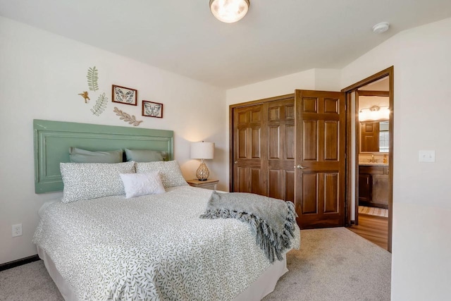 carpeted bedroom featuring ensuite bathroom and a closet