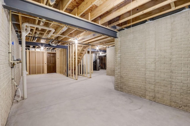 basement with water heater and brick wall