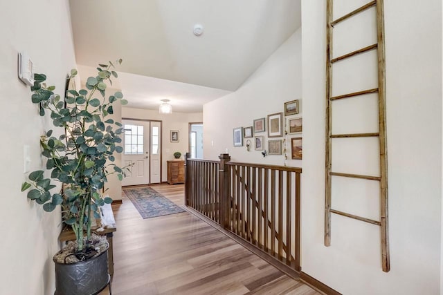 corridor featuring vaulted ceiling and light hardwood / wood-style flooring