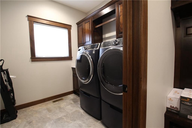 washroom featuring washer and clothes dryer and cabinets